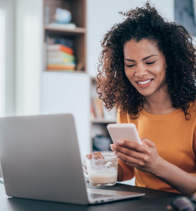 Woman who works from home in the finance industry smiling at phone 